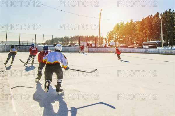 Caucasian boys playing ice hockey outdoors