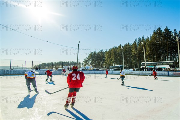 Caucasian boys playing ice hockey outdoors