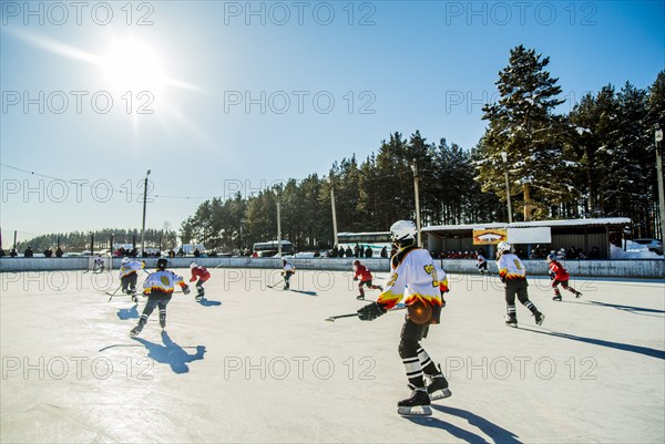 Caucasian boys playing ice hockey outdoors