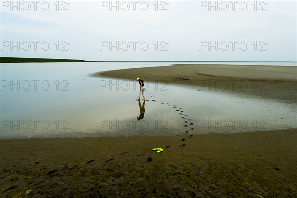 Footprints of woman wading at beach