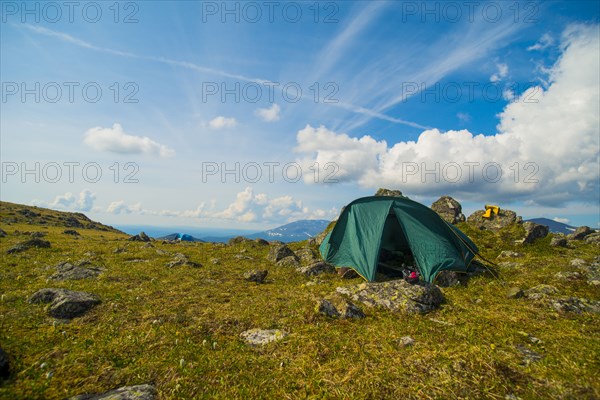 Green tent on rocky mountain