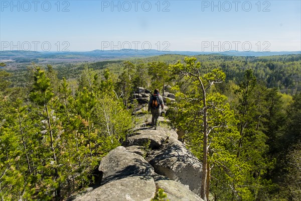 Caucasian man walking on mountain rock admiring scenic view