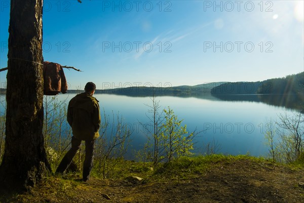 Caucasian man standing at lake admiring scenic view