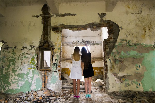 Women standing in doorway of dilapidated building