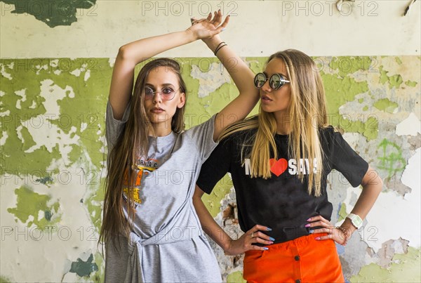 Women standing near dilapidated wall