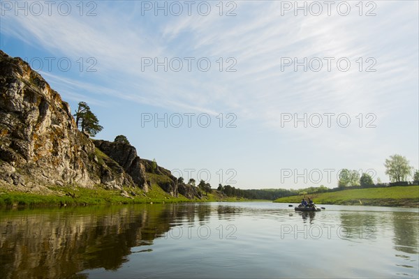 Caucasian men in inflatable raft on river