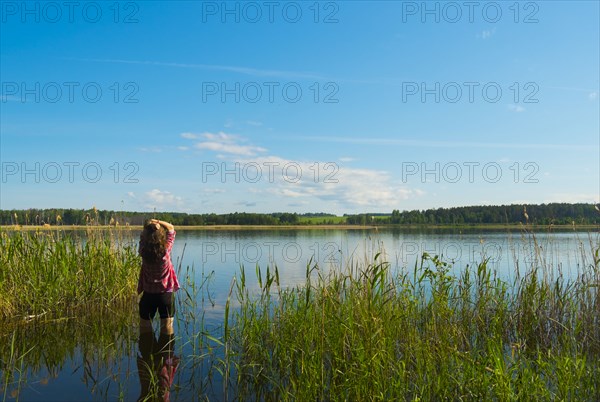 Caucasian woman wading in river