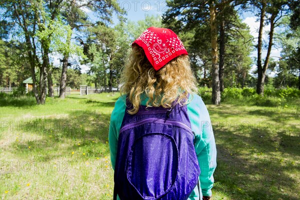 Woman wearing bandana carrying backpack in park