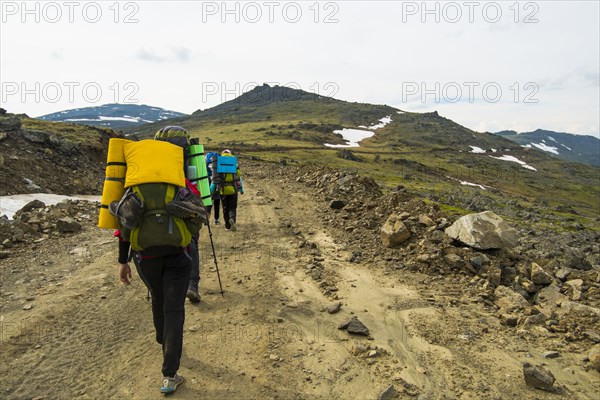 Hikers walking on mountain path in winter