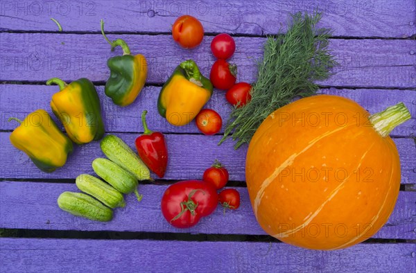 Fresh vegetables on purple wooden table