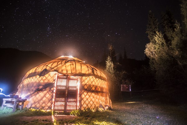 Shadows from bright glowing light inside yurt