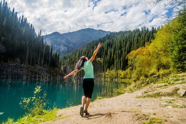 Carefree Caucasian woman walking near lake