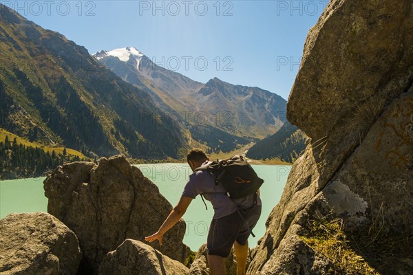 Caucasian man backpacking near mountain lake