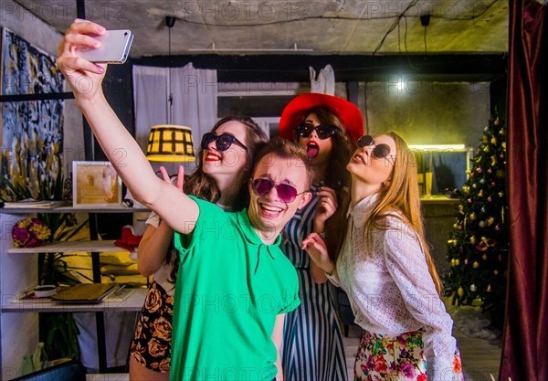 Fashionable Caucasian friends posing for cell phone selfie