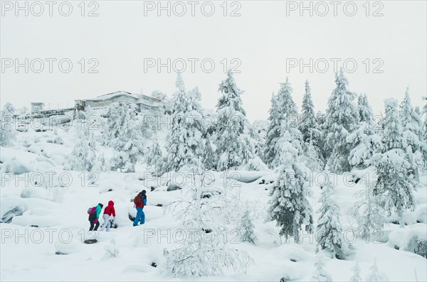 Caucasian friends hiking in snowy forest