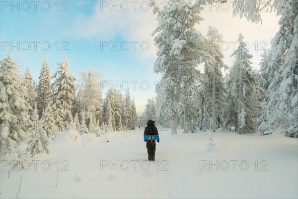 Caucasian man standing in snowy forest