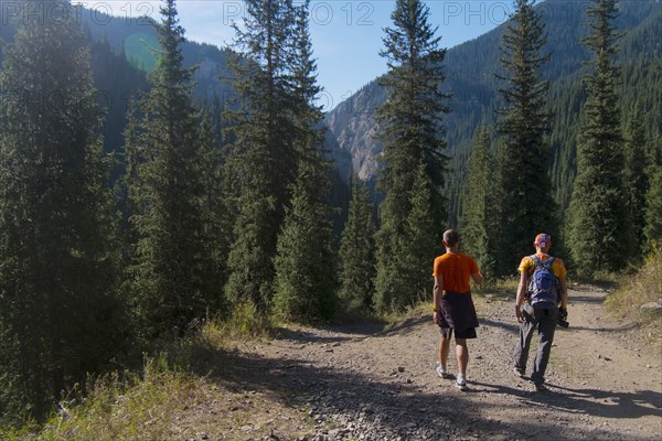 Caucasian men hiking on path in mountains