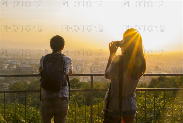 Caucasian couple photographing scenic view of cityscape