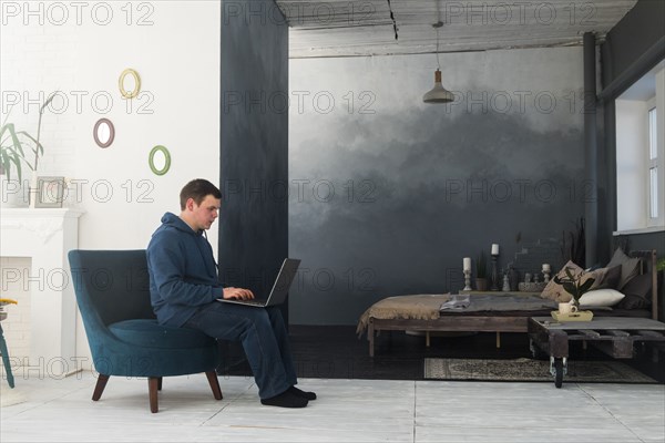 Caucasian man sitting in chair using laptop