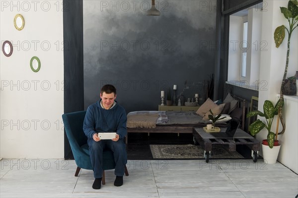 Caucasian man sitting in chair using digital tablet