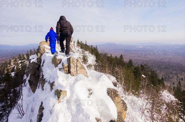 Caucasian men hiking on mountain in winter