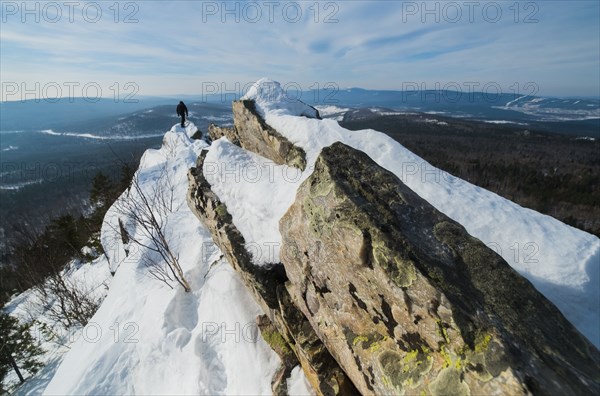 Caucasian man hiking on mountain in winter