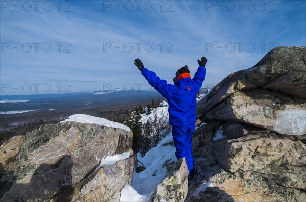 Caucasian man celebrating on mountain top in winter