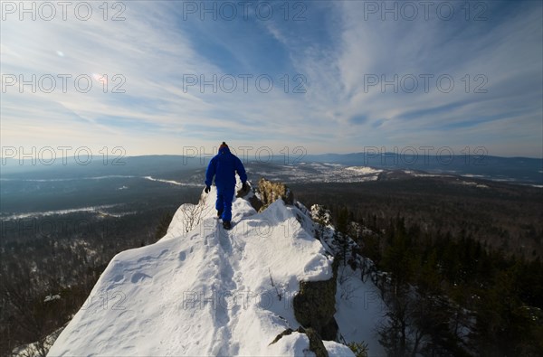 Caucasian man hiking on mountain top in winter