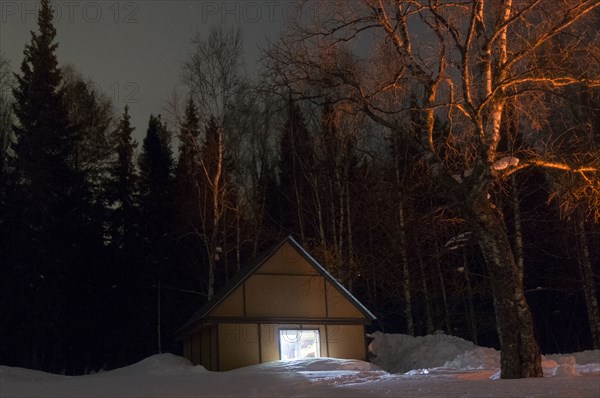 Light glowing in remote cabin in winter