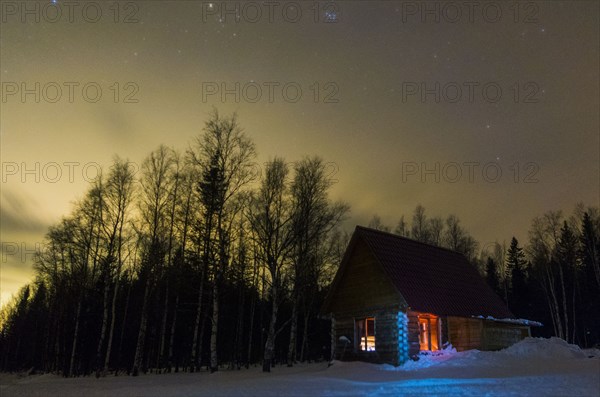 Light glowing in remote cabin in winter