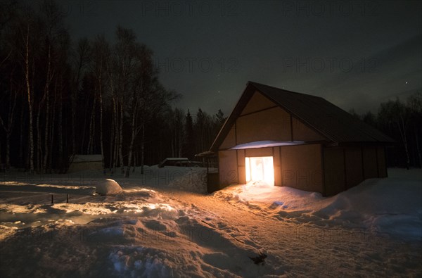 Light glowing in remote barn in winter