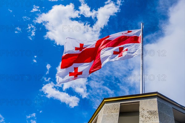 Flag blowing in wind on top of building