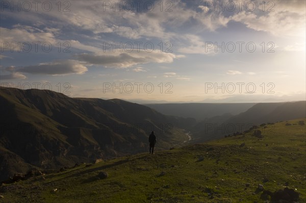Distant Caucasian man admiring scenic view of valley