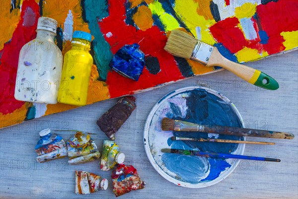 Painting supplies on table with canvas