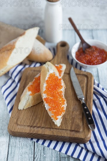 Bread with caviar on cutting board