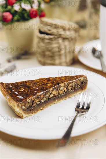 Slice of caramel tart on plate with fork