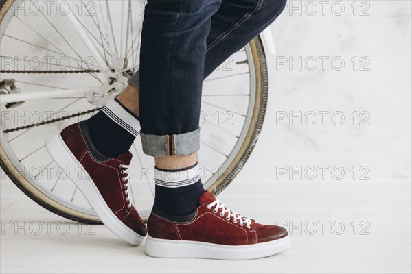 Legs of man standing near bicycle wheel