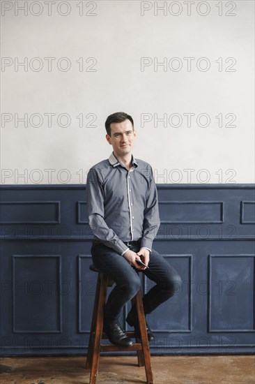 Portrait of Middle Eastern man sitting on stool