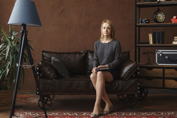 Portrait of Middle Eastern woman sitting on sofa