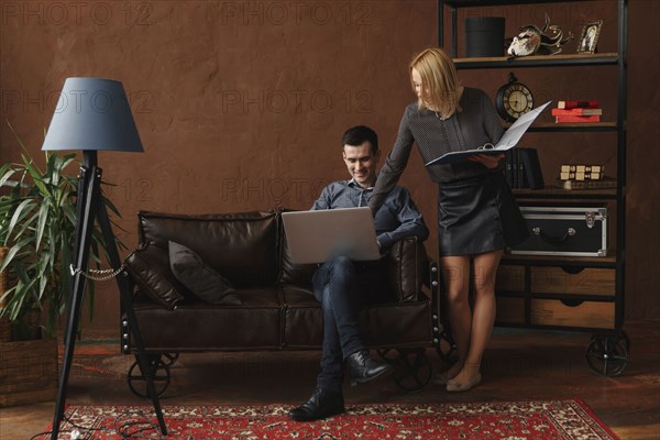 Middle Eastern couple using laptop in livingroom