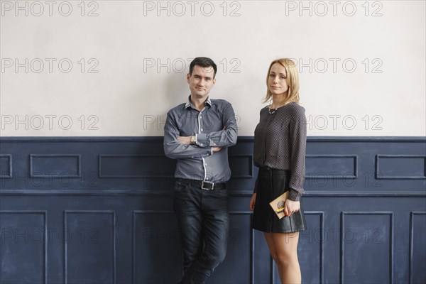 Portrait of Middle Eastern couple standing near wall