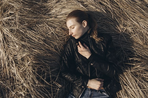 Middle Eastern woman resting in tall grass