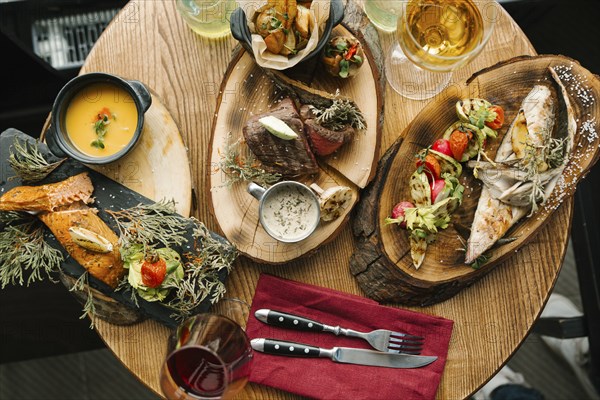 Variety of meat and fish on table with wine