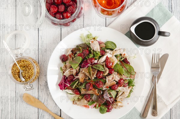 Plate of salad with chicken and cherry sauce