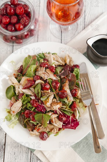 Plate of salad with chicken and cherry sauce