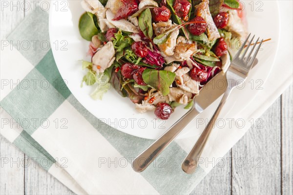 Plate of salad with chicken and cherry sauce