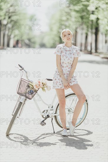 Portrait of Middle Eastern woman leaning on bicycle