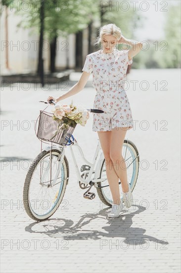 Middle Eastern woman standing near bicycle