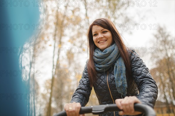 Smiling Middle Eastern woman pushing stroller