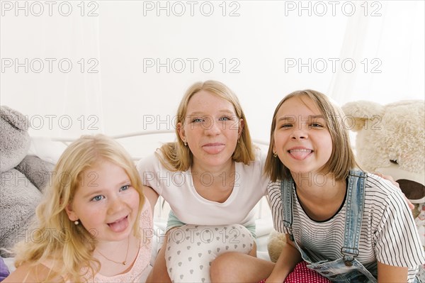 Portrait of smiling Middle Eastern sisters making a face